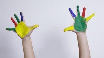 criatividade infantil, mãozinhas de criança pintadas em tintas coloridas na sala de aula em casa, conceito educacional para escola foto