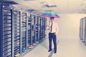empresário segura guarda-chuva na sala do servidor foto