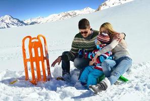 família se divertindo na neve fresca nas férias de inverno foto