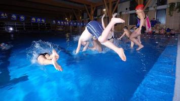 .crianças felizes pulando em uma piscina foto