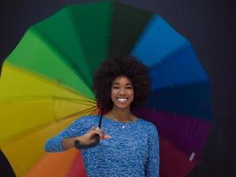 mulher afro-americana segurando um guarda-chuva colorido foto