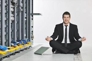homem de negócios pratica ioga na sala do servidor de rede foto