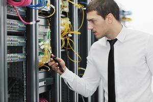 jovem engenheiro de TI na sala do servidor do datacenter foto