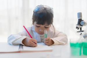 educação, ciência, química e conceito de crianças - crianças ou estudantes com tubo de ensaio fazendo experimento no laboratório da escola foto