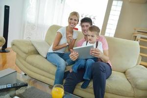 família em casa usando computador tablet foto