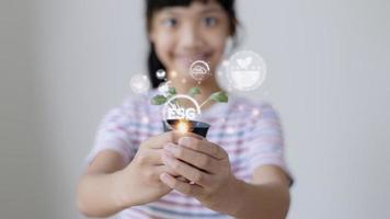 menina assistindo uma planta. conceito de tecnologia ambiental. metas de desenvolvimento sustentável. ex. foto