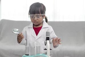 menina cientista desfrutar e excitar para examinar o produto químico de cor em laboratório usando conta-gotas com luz do dia. conceito de boas práticas e educação de ciências para apoio às crianças. foto