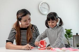 mãe ensina sua filha filha escovar os dentes com precisão foto