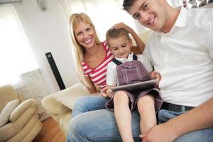 família em casa usando computador tablet foto