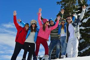 amigos se divertem no inverno na neve fresca foto