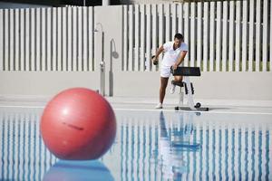 homem malhando na piscina foto