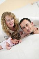 retrato interior com família jovem feliz e bebezinho fofo foto