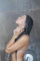 sexy jovem desfrutando de banho sob o chuveiro de água foto