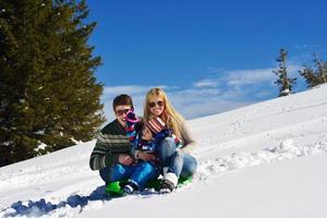 família se divertindo na neve fresca no inverno foto