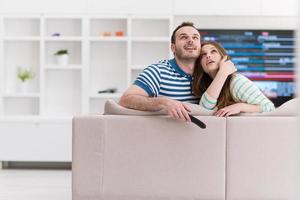 jovem casal no sofá assistindo televisão foto