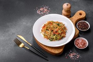 salada fresca de fatias finas de cenoura e abobrinha em um fundo de concreto foto