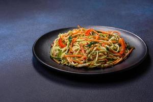 salada fresca de fatias finas de cenoura e abobrinha em um fundo de concreto foto