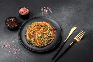 salada fresca de fatias finas de cenoura e abobrinha em um fundo de concreto foto