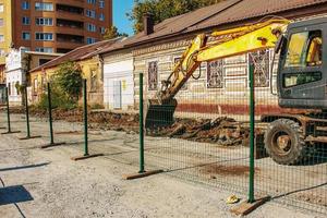 trabalhos de escavação. a caçamba do trator carrega o solo com uma pá na traseira de um caminhão basculante no canteiro de obras. foto