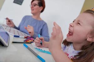 mãe e filha brincando juntas desenhando obras de arte criativas foto