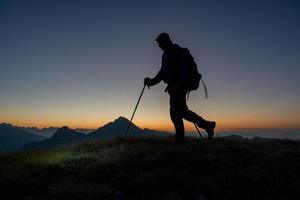 alpinista de manhã cedo andando com lanterna na cabeça foto