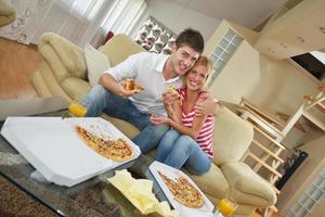 casal em casa comendo pizza foto