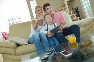 família em casa usando computador tablet foto