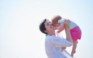 mãe e bebê na praia se divertem foto