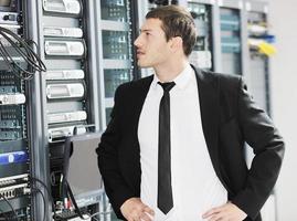 jovem engenheiro de TI na sala do servidor do datacenter foto