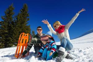 família se divertindo na neve fresca nas férias de inverno foto