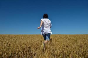 jovem no campo de trigo no verão foto