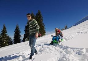 família se divertindo na neve fresca nas férias de inverno foto