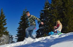 família se divertindo na neve fresca nas férias de inverno foto