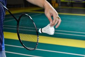 badminton indoor jogando servindo raquetes de petecas. conceito de jogo de badminton ao ar livre. foto