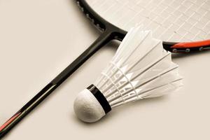 raquete de badminton e peteca de badminton contra fundo nublado e azul, conceito de jogo de badminton ao ar livre. foco seletivo na raquete. foto