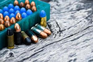 Balas de pistola de 9 mm e conchas de bala na mesa de madeira, foco suave e seletivo. foto