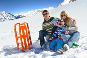 família se divertindo na neve fresca nas férias de inverno foto