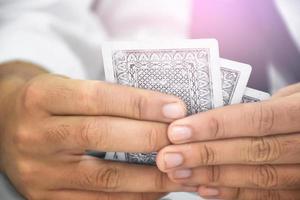 cartas de papel de pôquer nas mãos de uma mulher que está sentada e jogando cartas com amigo, foco suave e seletivo, tempos livres e atividade de hobby em casa conceito. foto