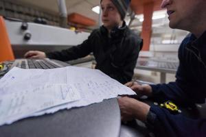 carpinteiros calculando e programando uma máquina de trabalhar madeira cnc foto