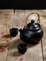 xícara de chá quente com jarros fumegantes no fundo da mesa de madeira com copyspace para o seu texto, estilo chinês