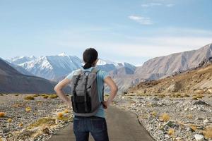 turista viajando com sua mochila na estrada e tire uma foto com câmera digital a beleza da paisagem, aventura e viagem no conceito, viagem de turismo na ásia leh ladakh, índia