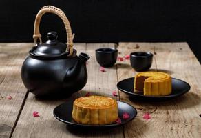 bolo de lua de comida deliciosa com uma xícara de chá quente no fundo da mesa de madeira com copyspace para o seu texto, conceito de festival tradicional chinês