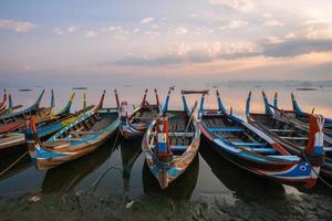 o barco local no lago taungthaman perto da ponte u bein a ponte de teca mais longa do mundo em amarapura, mianmar. foto