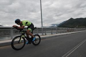 atleta de triatlo andando de bicicleta no treinamento matinal foto