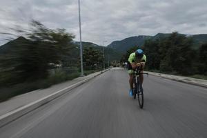 atleta de triatlo andando de bicicleta no treinamento matinal foto