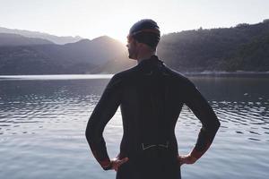 atleta de triatlo iniciando treinamento de natação no lago foto