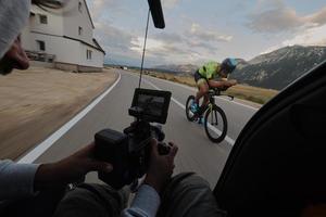 cinegrafista tomando uma foto de ação do atleta de bicicleta de triatlo