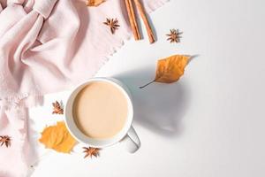 conceito de outono ou inverno com folhas de pinho e bordo, xícara de café, canela e cachecol, postura plana, vista superior. foto