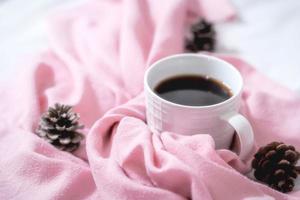 composição de natal. xícara de café, cachecol em fundo rosa. natal, conceito de inverno. configuração plana, vista superior, espaço de cópia foto