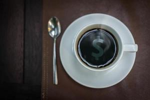 café quente com reflexo de sinal de dinheiro no topo, conceito de negócio foto